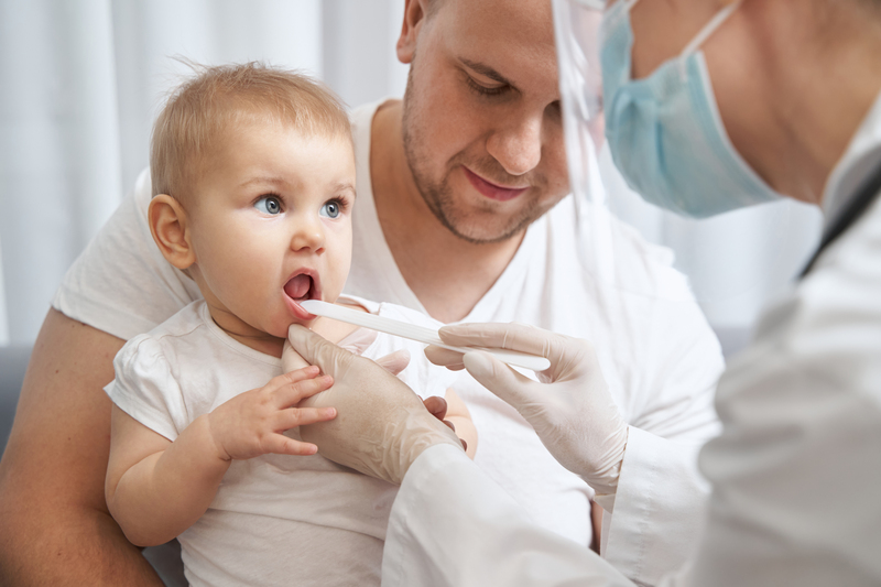 medic examineaza limba bebelusului cu o spatula